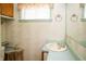 A small bathroom with floral wallpaper, a window, and a single sink vanity at 1821 E Stop 10 Rd, Indianapolis, IN 46227