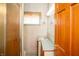 A small bathroom with floral wallpaper, a window, a single sink vanity, and a shower at 1821 E Stop 10 Rd, Indianapolis, IN 46227