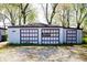 Exterior view of a multi-car garage, featuring three separate garage doors at 1821 E Stop 10 Rd, Indianapolis, IN 46227