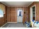 Spare room with paneled walls, an open exterior door, and an adjacent window at 1821 E Stop 10 Rd, Indianapolis, IN 46227