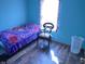 Bright bedroom featuring a single bed, accent chair, and wood-look flooring at 1835 Carpenter Cir, Indianapolis, IN 46203