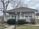 Charming home featuring a cozy front porch, gray siding, and a well-maintained landscaped yard at 1835 Carpenter Cir, Indianapolis, IN 46203