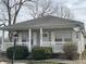 Charming home featuring a cozy front porch, gray siding, and a well-maintained landscaped yard at 1835 Carpenter Cir, Indianapolis, IN 46203