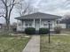 Cozy home featuring a classic front porch, neutral siding, and a simple landscaped front yard at 1835 Carpenter Cir, Indianapolis, IN 46203