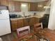 Functional kitchen area with wooden cabinets, essential appliances, and eat-in dining space at 1835 Carpenter Cir, Indianapolis, IN 46203