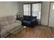 Cozy living room featuring a neutral sofa, black loveseat, glass coffee table, and natural light at 1835 Carpenter Cir, Indianapolis, IN 46203