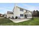 Back exterior of a beige house features a large concrete patio and a spacious, green lawn at 18358 Benton Oak Dr, Noblesville, IN 46062