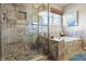Luxurious bathroom features glass enclosed shower and separate soaking tub with stone tile surround at 18358 Benton Oak Dr, Noblesville, IN 46062