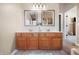 Bathroom features an expansive wood vanity with double sinks, framed mirrors and stylish lighting at 18358 Benton Oak Dr, Noblesville, IN 46062