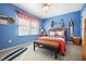 Stylish bedroom featuring blue walls, a woven bed frame, and surf-themed decor at 18358 Benton Oak Dr, Noblesville, IN 46062