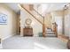 Bright foyer features staircase, rug, and decorative cabinet at 18358 Benton Oak Dr, Noblesville, IN 46062