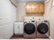Well-lit laundry room with modern washer and dryer, sink, storage, and stylish wooden cabinets at 18358 Benton Oak Dr, Noblesville, IN 46062