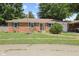 Charming brick ranch-style home with a well-manicured lawn, blue shutters, and an American flag at 1906 E Markwood Ave, Indianapolis, IN 46227