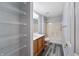 The bathroom features wood cabinets, a tub and shower combo, neutral walls, and vinyl plank flooring at 1975 Westminster Pl, Columbus, IN 47201