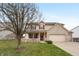 Charming two-story home featuring a welcoming front porch and a spacious two-car garage on a landscaped lawn at 1975 Westminster Pl, Columbus, IN 47201