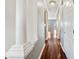 Bright hallway with hardwood floors, column details, and white trim, leading to various rooms within the home at 1975 Westminster Pl, Columbus, IN 47201