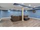 Basement living room area with gray sofa and wood-look flooring at 2091 Banburry Pl, Avon, IN 46123