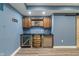 Finished basement wet bar area with barrel accents, wooden cabinets, wine fridge, and modern sink at 2091 Banburry Pl, Avon, IN 46123