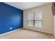 Bedroom featuring neutral carpet, blue accent wall, and a window providing ample natural light at 2091 Banburry Pl, Avon, IN 46123