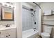 Bright bathroom featuring tiled shower and tub, sleek fixtures, vanity, and organized shelving at 2155 S Delaware St, Indianapolis, IN 46225