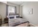 Cozy bedroom featuring a large window with blinds, gray curtains, and a comfortable bed with decorative pillows at 2155 S Delaware St, Indianapolis, IN 46225