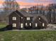 Two-story brick home exterior featuring warm lighting and a sunset backdrop at 2525 Sunderland Dr, Martinsville, IN 46151
