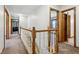 Bright hallway with wood railing, neutral walls, and multiple open doorways at 2525 Sunderland Dr, Martinsville, IN 46151