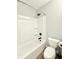Bright bathroom featuring a white tub and toilet alongside dark fixtures and storage space at 2638 Calbert Dr, Indianapolis, IN 46219