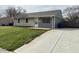 Cozy single-story home with a well-manicured lawn, gray siding, and a concrete driveway at 2638 Calbert Dr, Indianapolis, IN 46219