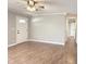 Open living room showcasing wood-look floors, new paint, white trim, ceiling fan, and passageway to bedrooms at 2638 Calbert Dr, Indianapolis, IN 46219