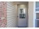 Close-up of the front door, with a glass panel and beige siding at 3013 Crimson W Ct # 42, Carmel, IN 46033