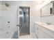 Bathroom features a shower, view down the hallway, and a classic vanity with a mirror and soft lighting at 350 N Belleview Pl, Indianapolis, IN 46222