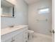 Bright bathroom featuring a single sink vanity, mirror, and toilet, complemented by light-colored walls and flooring at 350 N Belleview Pl, Indianapolis, IN 46222
