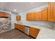 This kitchen features wood cabinets, granite counters, stainless steel appliances, new dark floors, and stone wall accent at 350 N Belleview Pl, Indianapolis, IN 46222