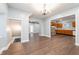 Open concept living room features new dark floors, chandelier lighting, and kitchen with stone wall accent at 350 N Belleview Pl, Indianapolis, IN 46222