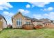 A well-kept lawn meets a brick home with a wooden deck, complemented by neat landscaping at 4703 River Ridge Dr, Indianapolis, IN 46240