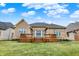 Expansive brick home featuring a wood deck and a well-maintained lawn under a sunny, blue sky at 4703 River Ridge Dr, Indianapolis, IN 46240