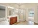 Light-filled bathroom with corner shower, vanity, and a view of the lake at 4703 River Ridge Dr, Indianapolis, IN 46240