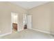 Bright bedroom with neutral carpet, leading to a bathroom with a wood vanity and updated fixtures at 4703 River Ridge Dr, Indianapolis, IN 46240