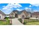 Elegant brick home with a manicured front yard, wrought iron fence, and a private driveway at 4703 River Ridge Dr, Indianapolis, IN 46240
