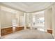 Spacious living room with hardwood floors, pillars, fireplace, and large windows overlooking the water at 4703 River Ridge Dr, Indianapolis, IN 46240