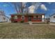 Classic brick ranch home with covered porch and mature landscaping, set against a cloudy sky at 4812 Eastgate Dr, Columbus, IN 47203