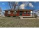 Inviting single-story brick home featuring a cozy covered front porch, green shutters and landscaped garden at 4812 Eastgate Dr, Columbus, IN 47203