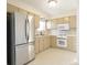 Well-lit kitchen featuring stainless steel refrigerator and range, and light colored cabinets at 4812 Eastgate Dr, Columbus, IN 47203