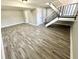 Spacious finished basement with wood-look floors and a staircase leading to the upper level at 5608 Lunsford Dr, Indianapolis, IN 46237