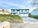 Charming light blue two-story home featuring a two-car garage, well-maintained lawn, and a welcoming front entrance at 5608 Lunsford Dr, Indianapolis, IN 46237
