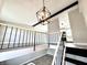 Modern living space featuring a decorative light fixture, staircase, and views into the kitchen at 5608 Lunsford Dr, Indianapolis, IN 46237