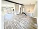 Open living room with gray flooring, an adjacent dining area, access to the patio, and modern lighting fixtures at 5608 Lunsford Dr, Indianapolis, IN 46237