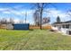 Spacious backyard featuring lush grass, patio seating, a utility shed and carport at 5887 Meadowlark Dr, Indianapolis, IN 46226