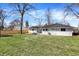 Large backyard area with green grass, a privacy fence, and a patio set at 5887 Meadowlark Dr, Indianapolis, IN 46226